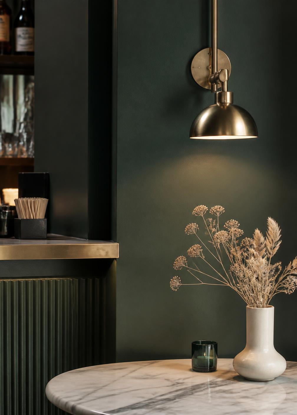 Interieurdetail met messing wandlamp en marmeren tafel